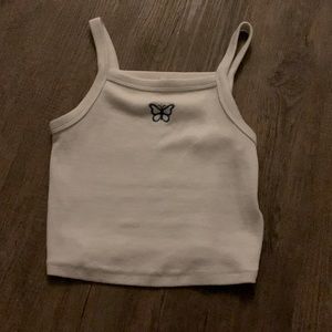 White crop tank with a blue butterfly from Garage🤍🦋